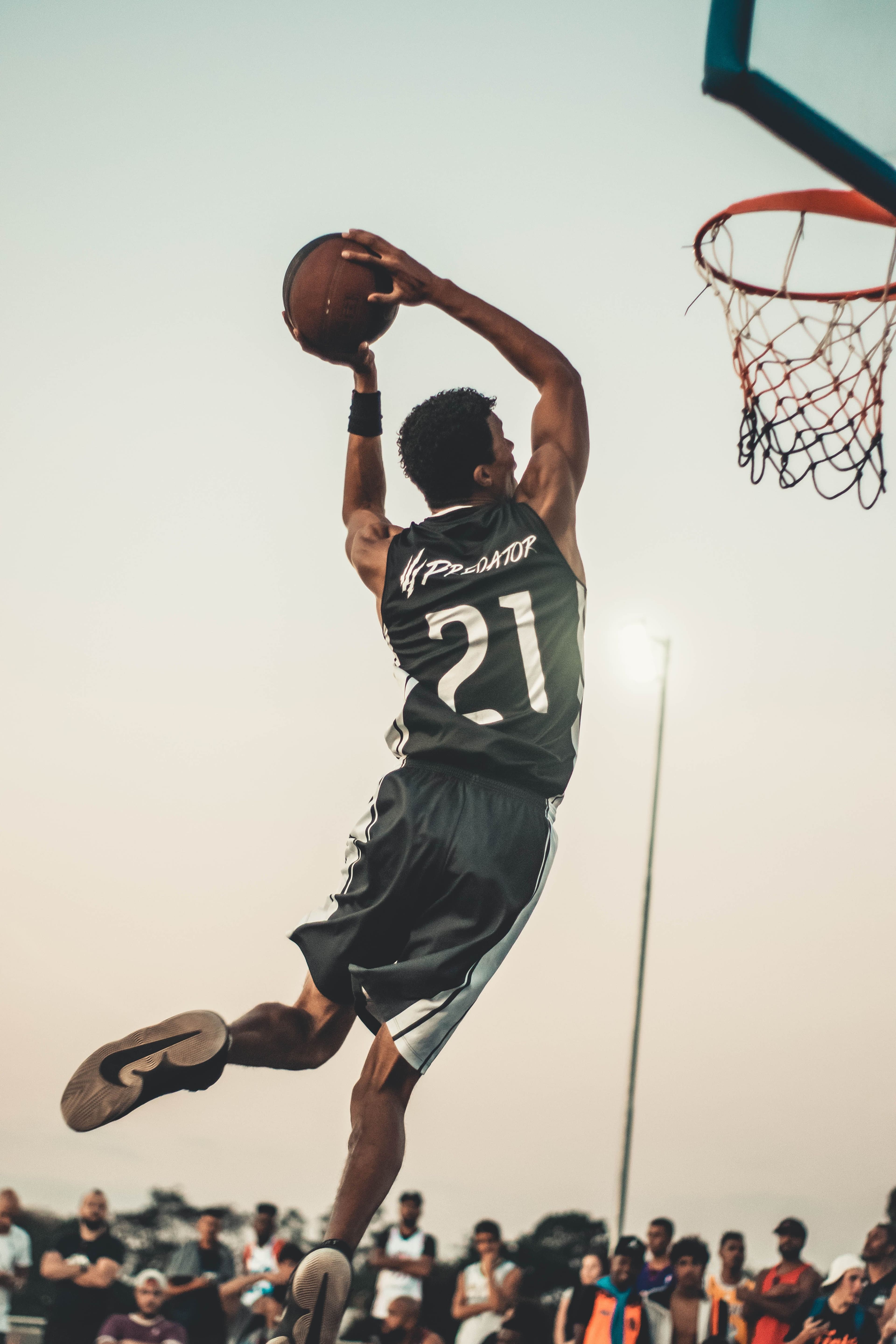 Action de dunk pendant un match de basket devant le public.